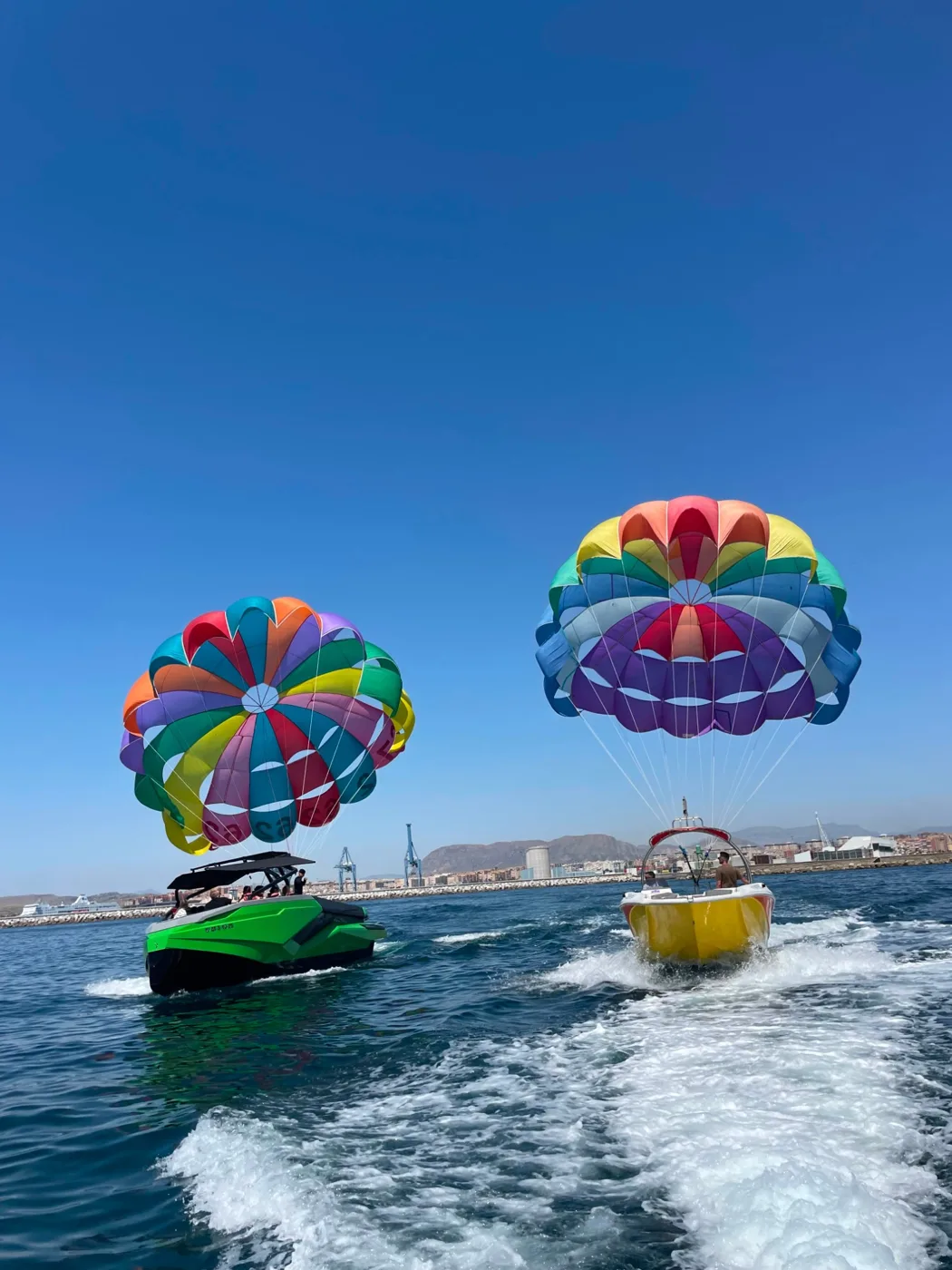 Dos barcos de parasailing saliendo del puerto